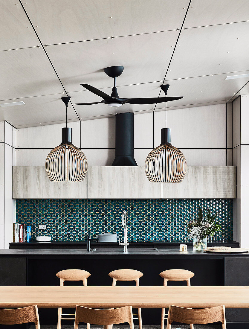 View over the dining area onto the kitchen island and honeycomb-shaped tiles as splash protection