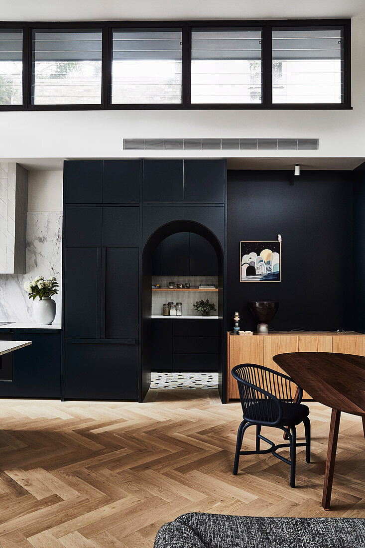 High, open living room with black fixtures and arched neckline