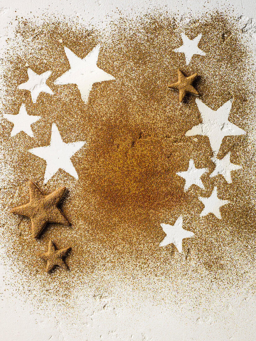 Sternplätzchen und sternförmige Abdrücke im Zimtpulver