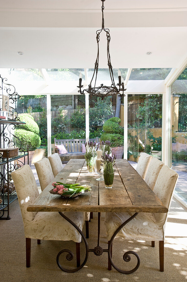 Wooden table and chairs with cream upholstery in country-house-style dining area