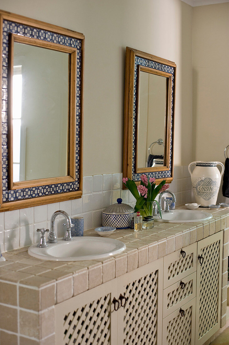 Badezimmer im Landhausstil mit zwei Mosaikrahmenspiegeln über gefliestem Waschtisch