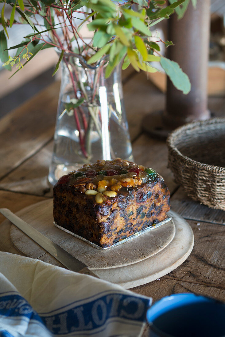 Ein Stück Früchtekuchen auf rustikalem Holzbrett