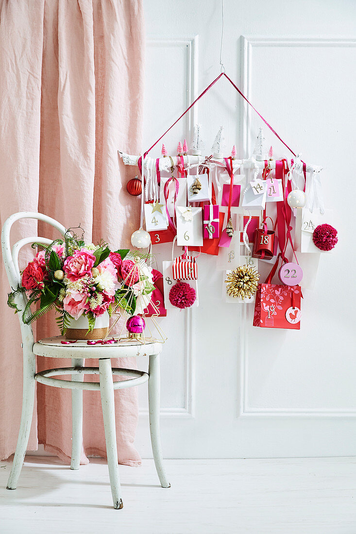 Blumenbouquet auf Stuhl dahinter DIY-Adventskalender in Weiß, Rot und Rosa