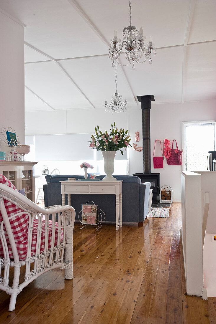 Wohnzimmer im Landhausstil mit Holzdielenboden, Holzofen und Kronleuchtern