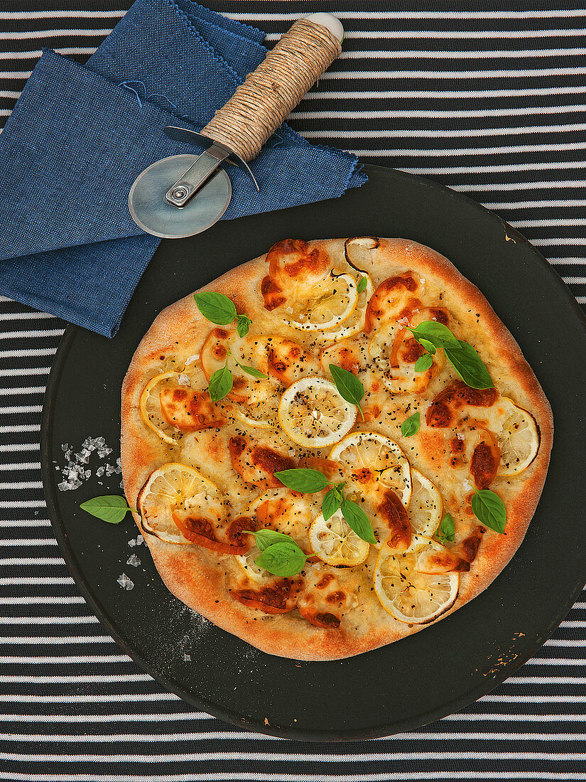Pizza mit Räucherkäse, Zitrone und Basilikum