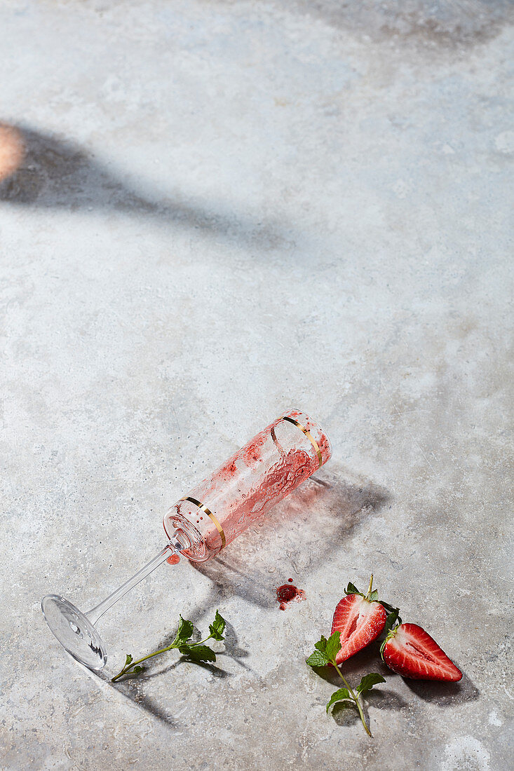 An empty cocktail glass and strawberries