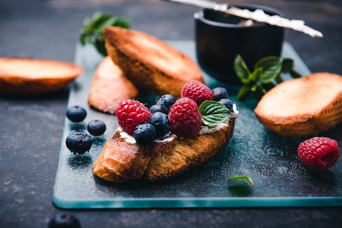 Geröstete Baguettescheiben mit Mandelfrischkäse, Beeren und Minze (vegan)