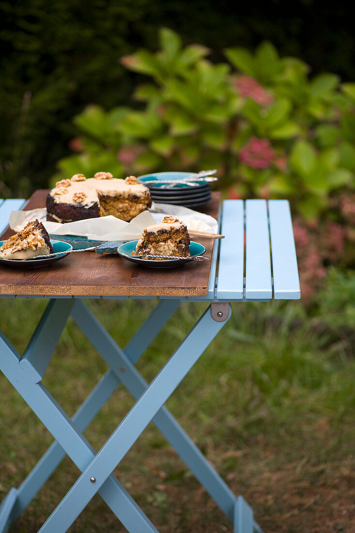 Gluten-free carrot cake with vanilla-cashew cream cheese on a garden table