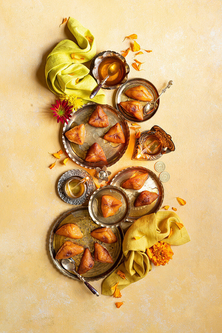 Diwali Special - Sweet Potato Dumplings with Indian traditional brass candles, yellow napkin, flowers