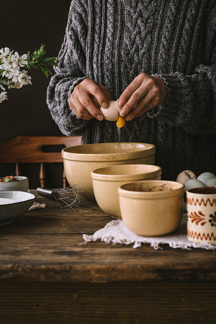 A woman cooking a bundt cake at home in a rustic kitchen, on a wooden table