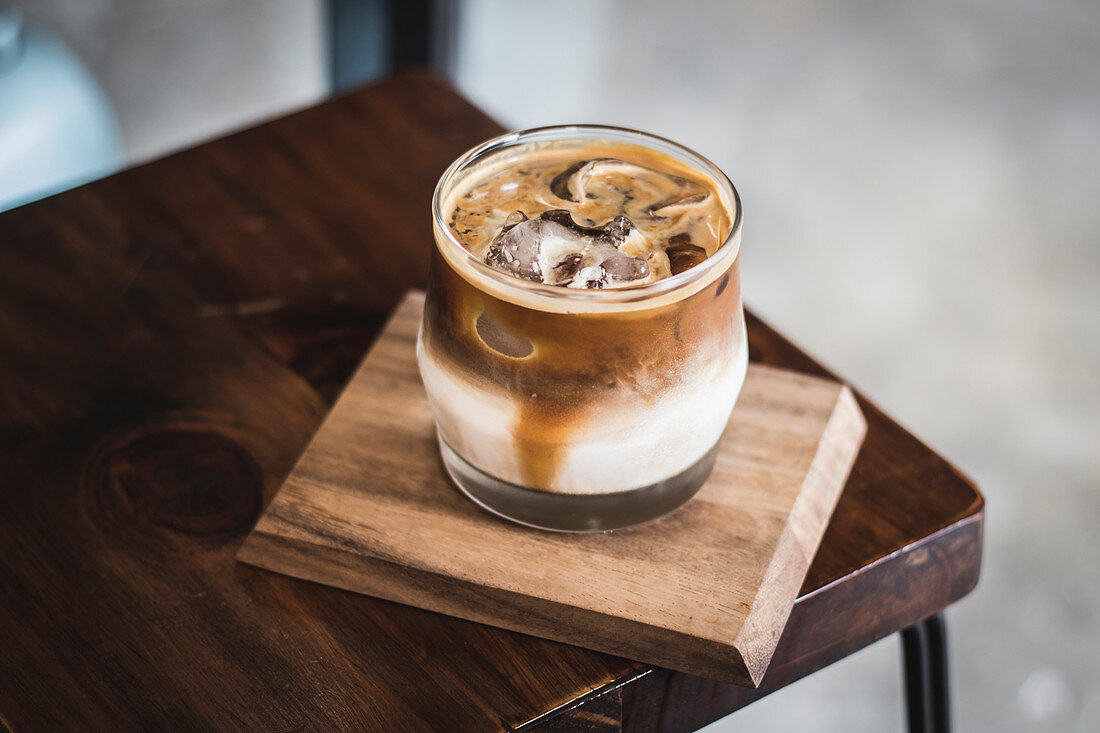 Iced coffee with milk on a wooden board