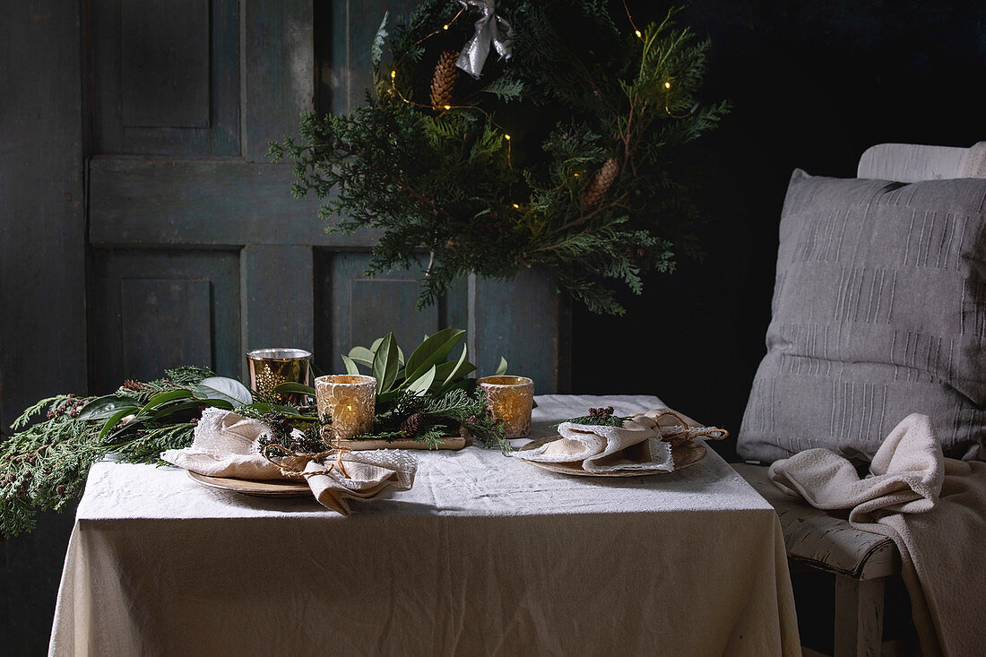 Thuja-Kranz mit Lichterkette über weihnachtlich gedecktem Tisch