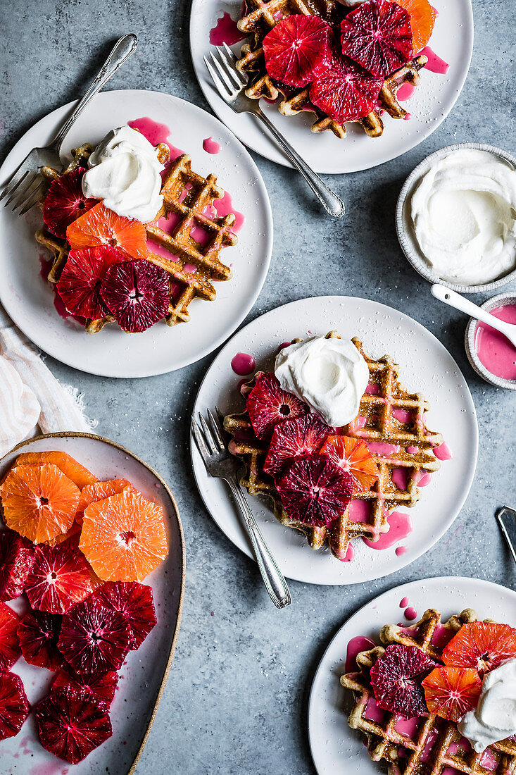 Fluffy and crispy chamomile waffles made gluten-free with oat, sweet rice, and tapioca flours Drizzled with hot pink blood orange glaze and topped with festive orange supremes and whipped cream