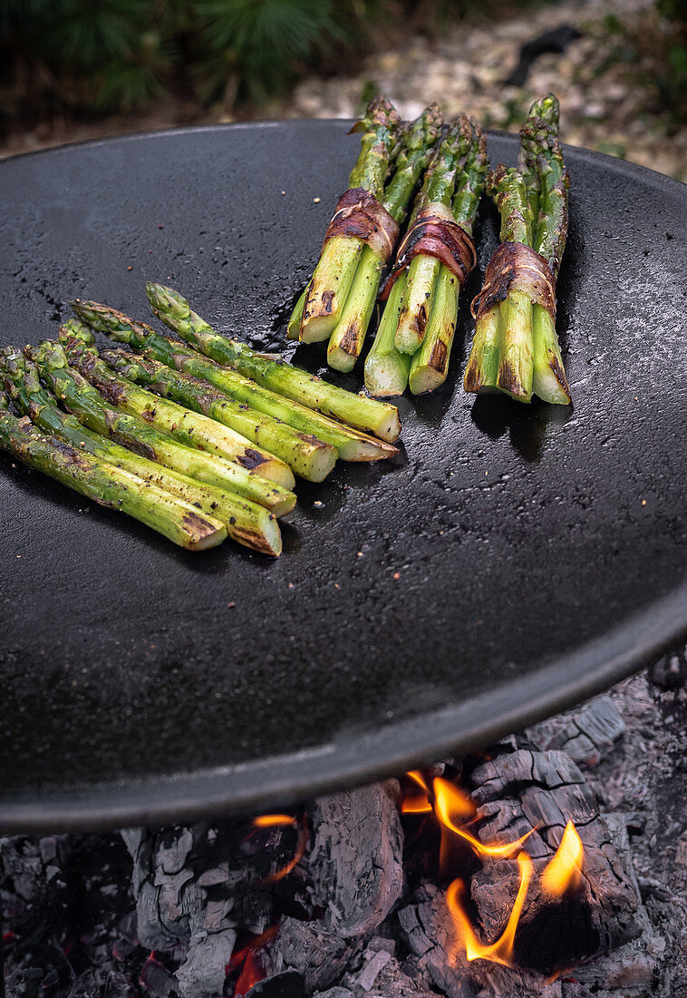 Grilled green asparagus with bacon on a charcoal grill