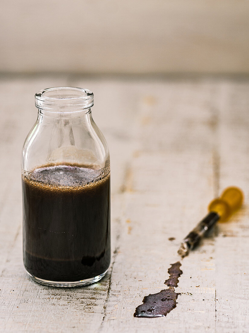 Kaffee-Gin-Öl in Glasflasche und Pipette