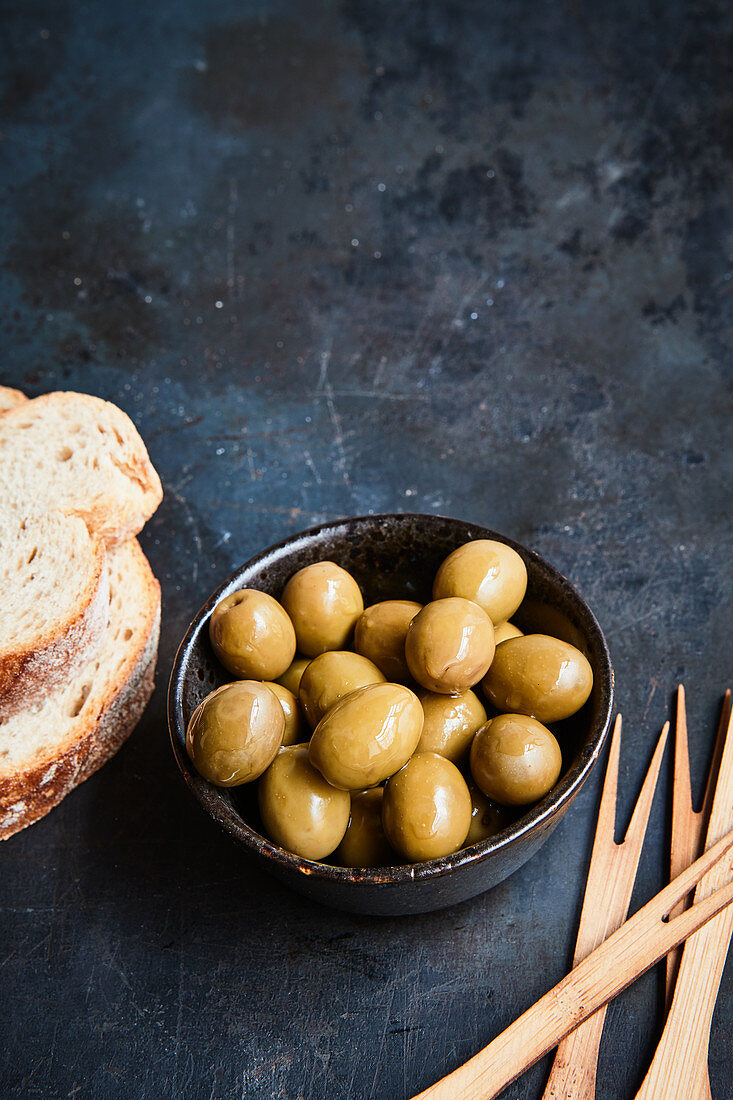 Grüne Oliven, Weißbrot und Spiesschen