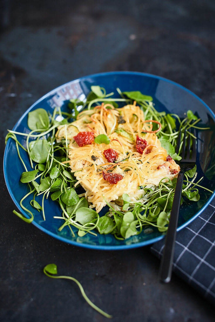 Spaghetti cake with dried tomatoes on purslane