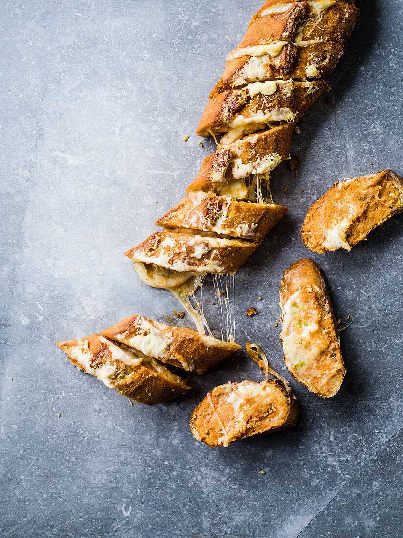 Knoblauchbaguette mit Käse, Zwiebeln und Sriracha