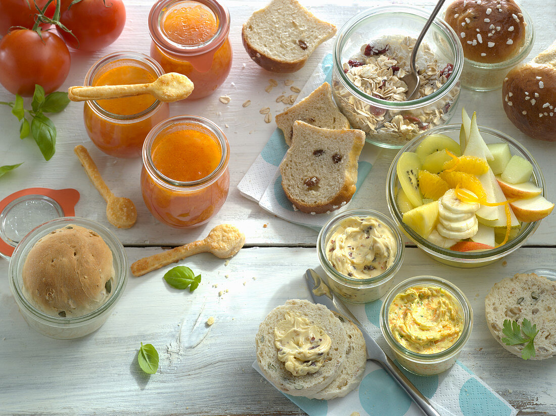 Brunch mit Brot aus dem Glas, Marmelade, Dips, Müsli und Obstsalat