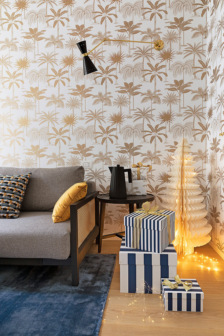Gifts in striped boxes and wallpaper with palm-leaf pattern in living room