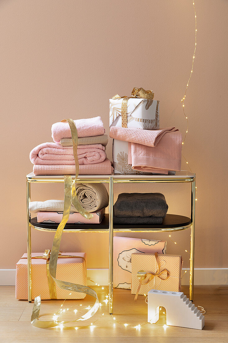 Towels and wrapped gifts on golden shelves