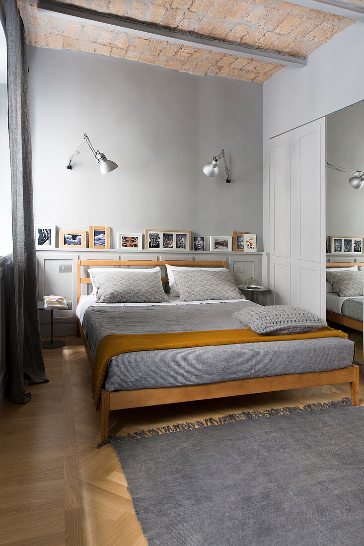 Bed in bedroom in shades of grey with vaulted ceiling