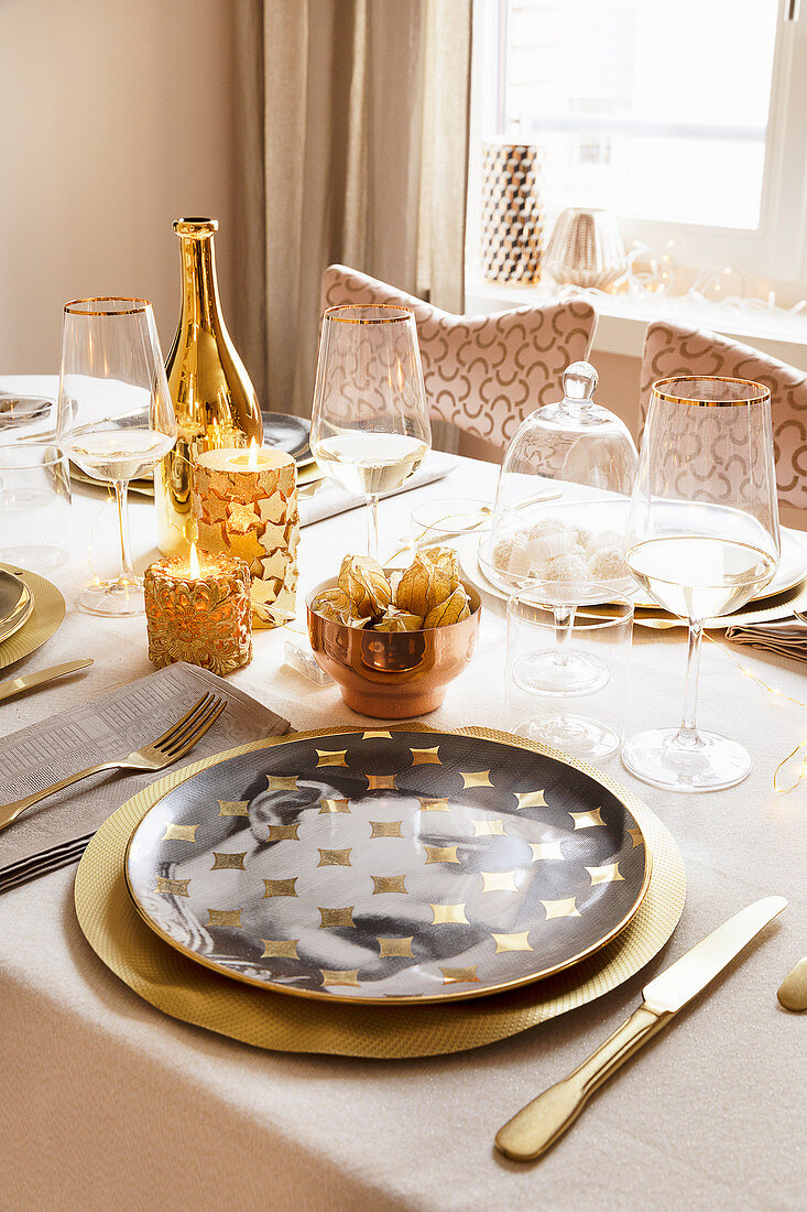 Festlich gedeckter Tisch in Gold und Weiß mit Portrait-Tellern