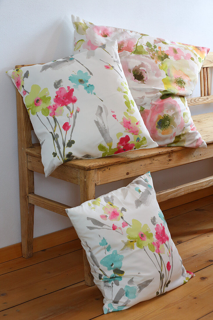 Floral scatter cushions on wooden bench