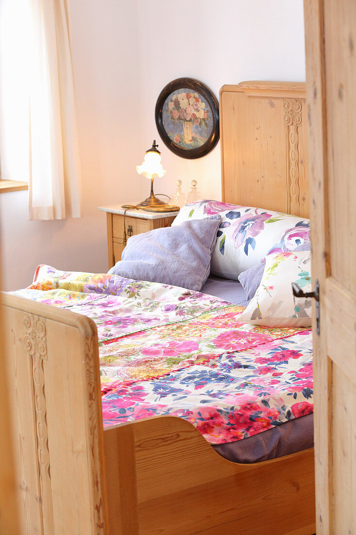 Floral bed linens on wooden bed