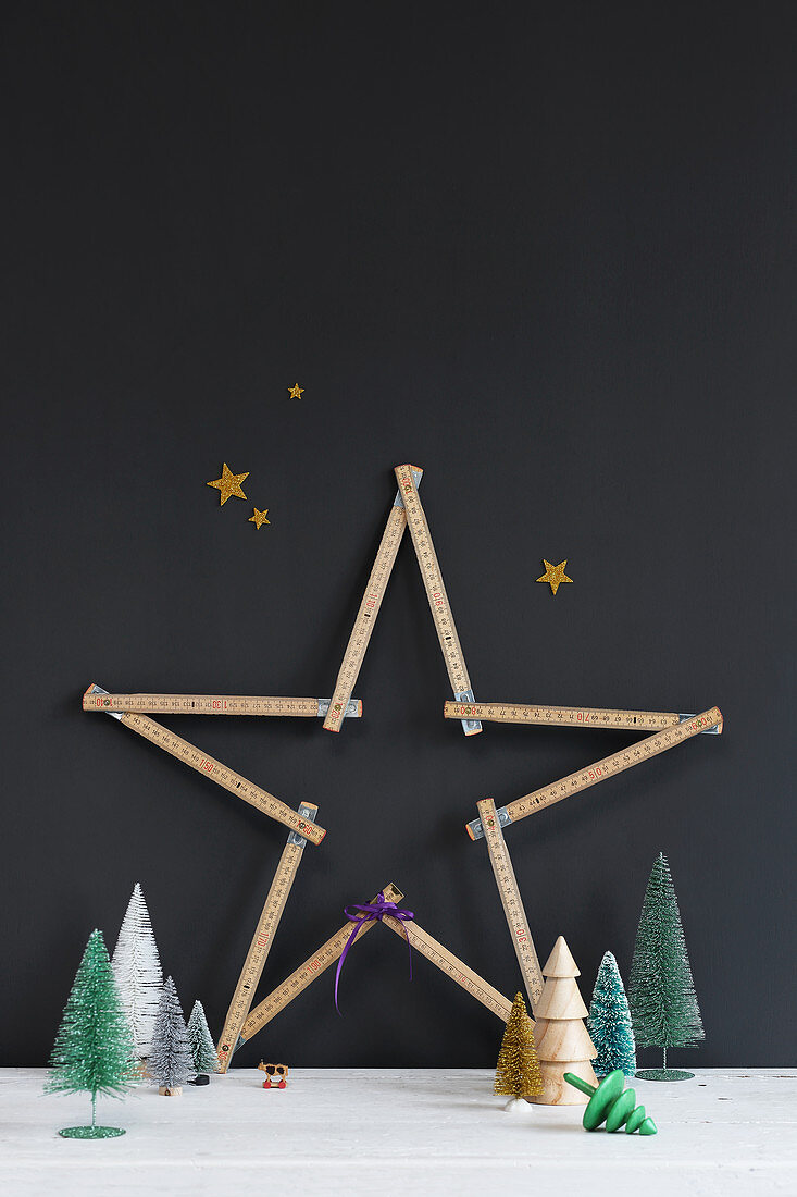 Christmas star made from folding rule against black wall