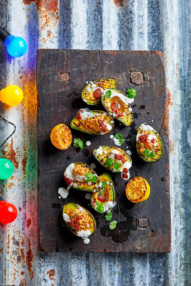 Grilled avocado halves with harissa hummus and tahini yogurt