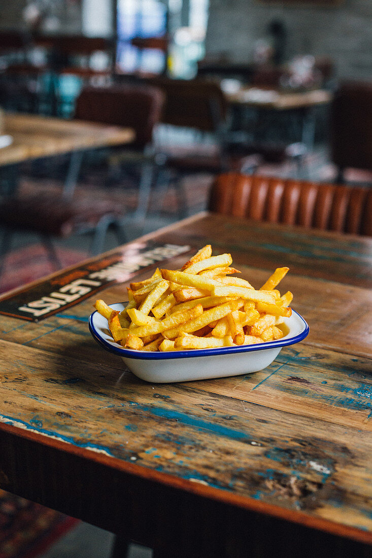 French fries in a bowl on rustic wooden table