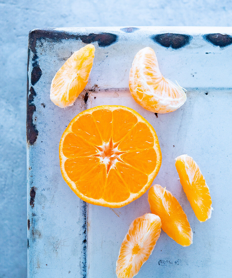 Clementinen, halbe Frucht und Spalten