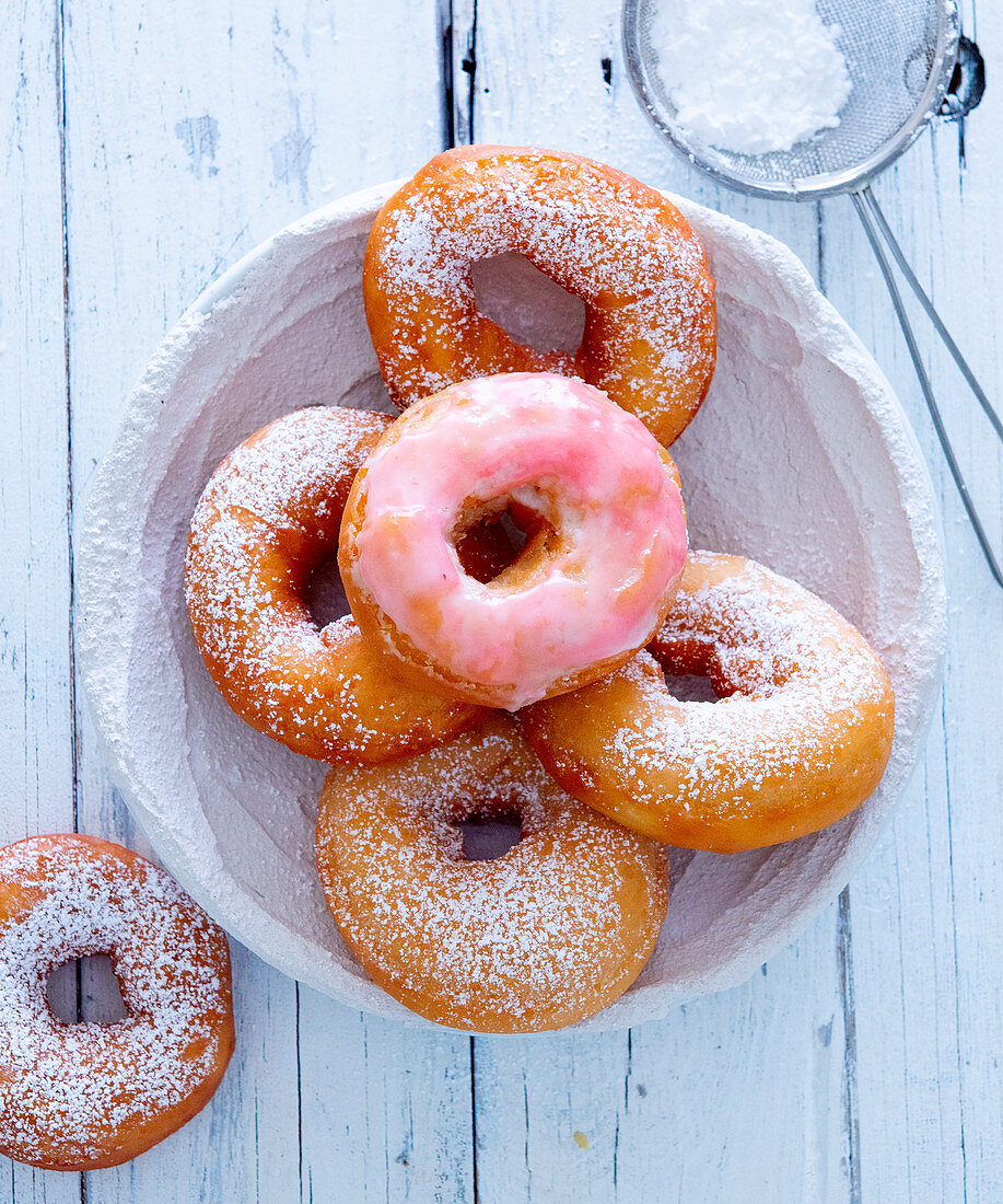 Donuts with pink icing and powdered sugar