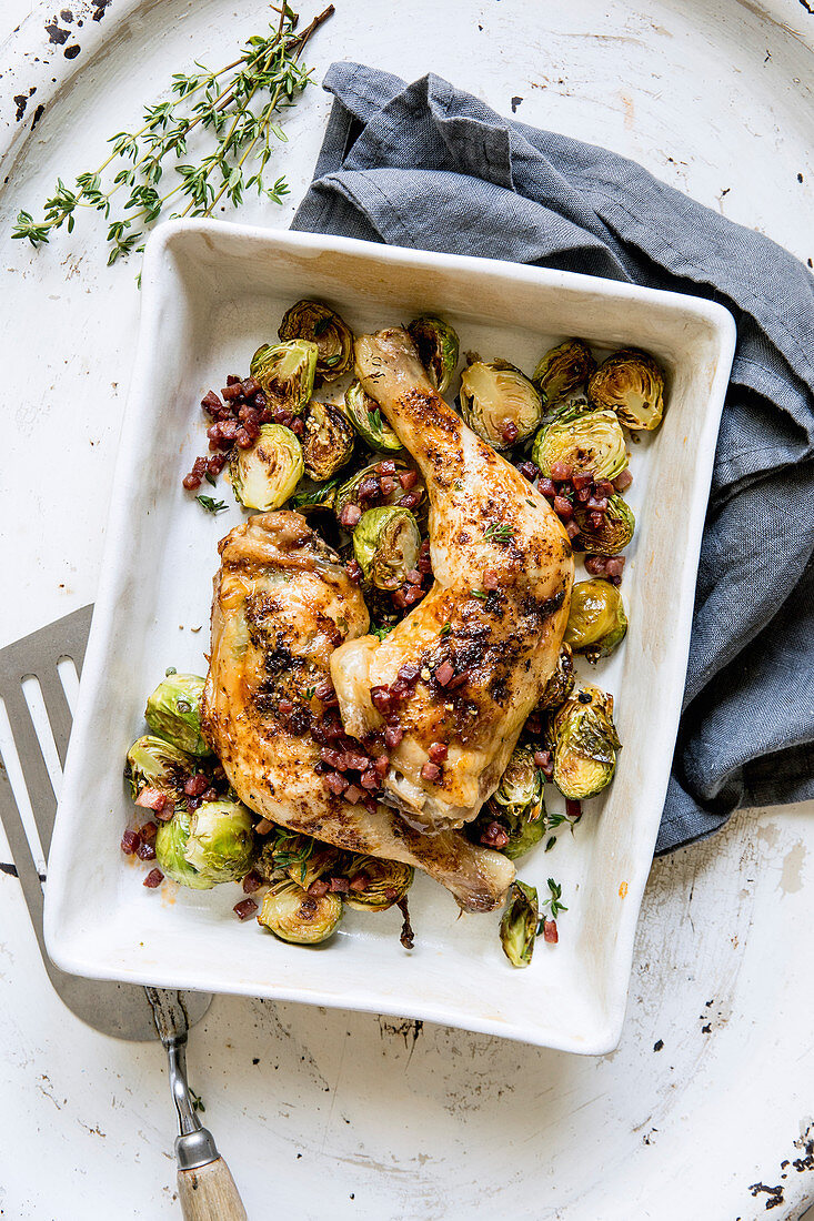 Chicken legs with roast Brussels sprouts and bacon cubes