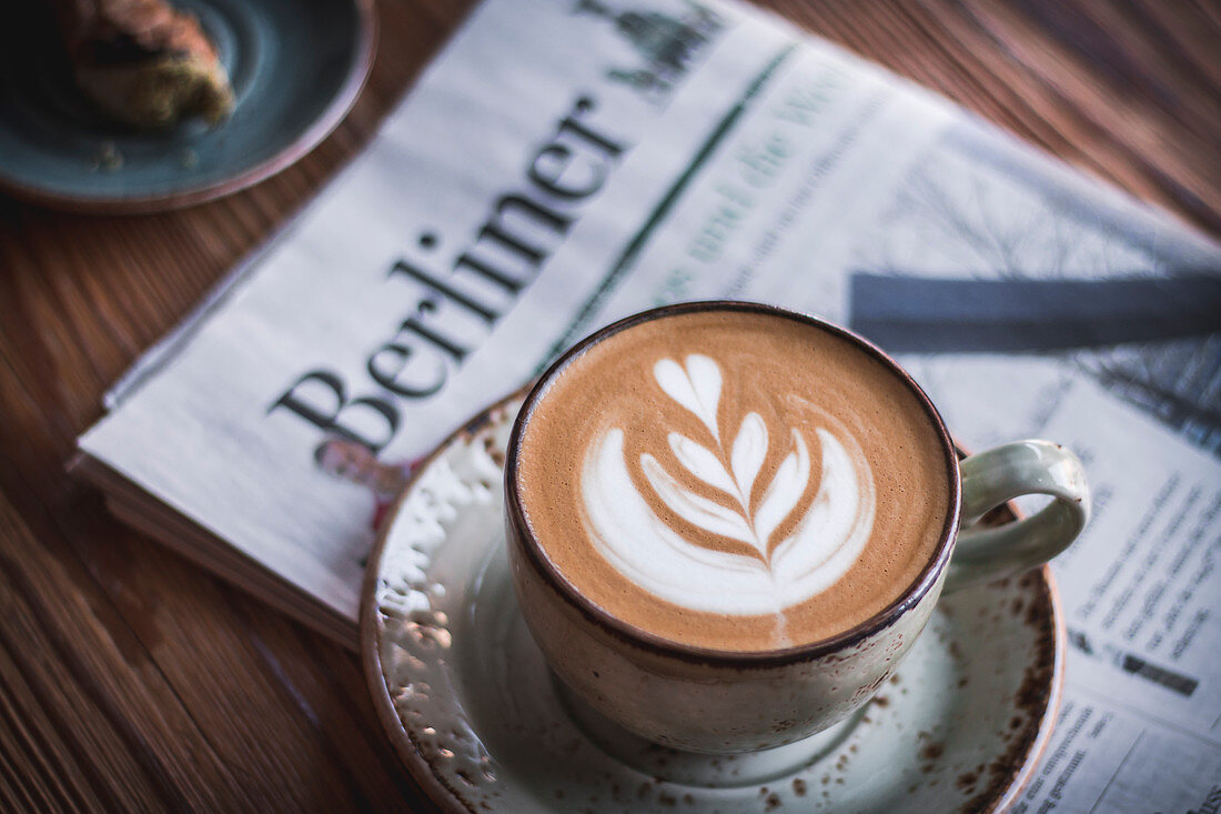 Cappuccino with latte art on a newspaper