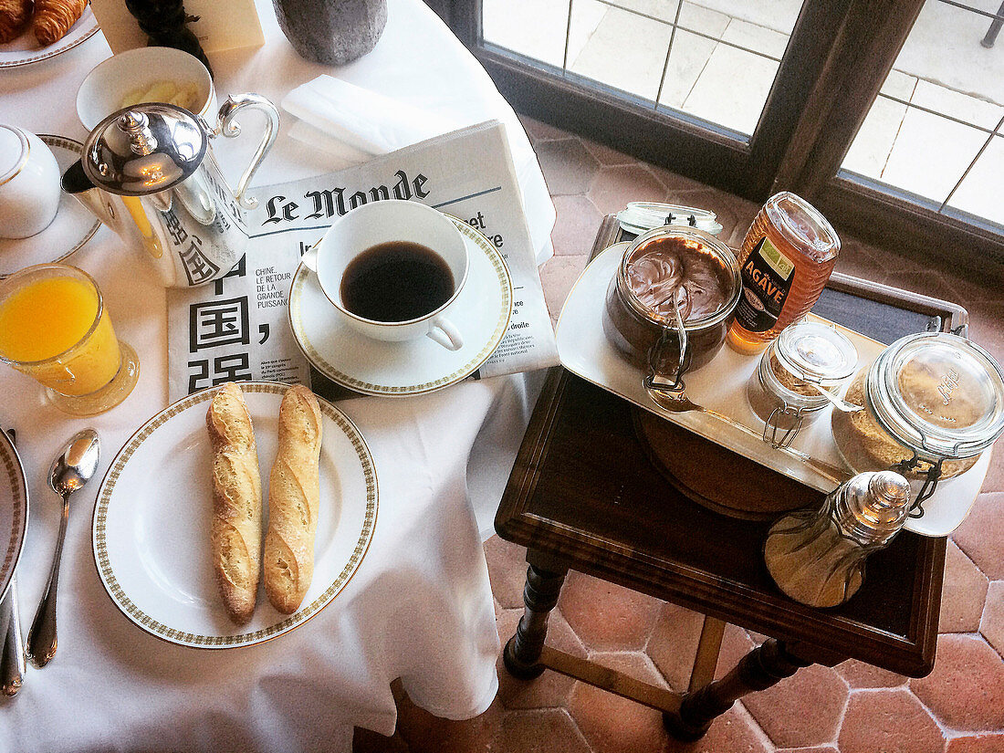 Französisches Frühstück mit Kaffee und Baguette
