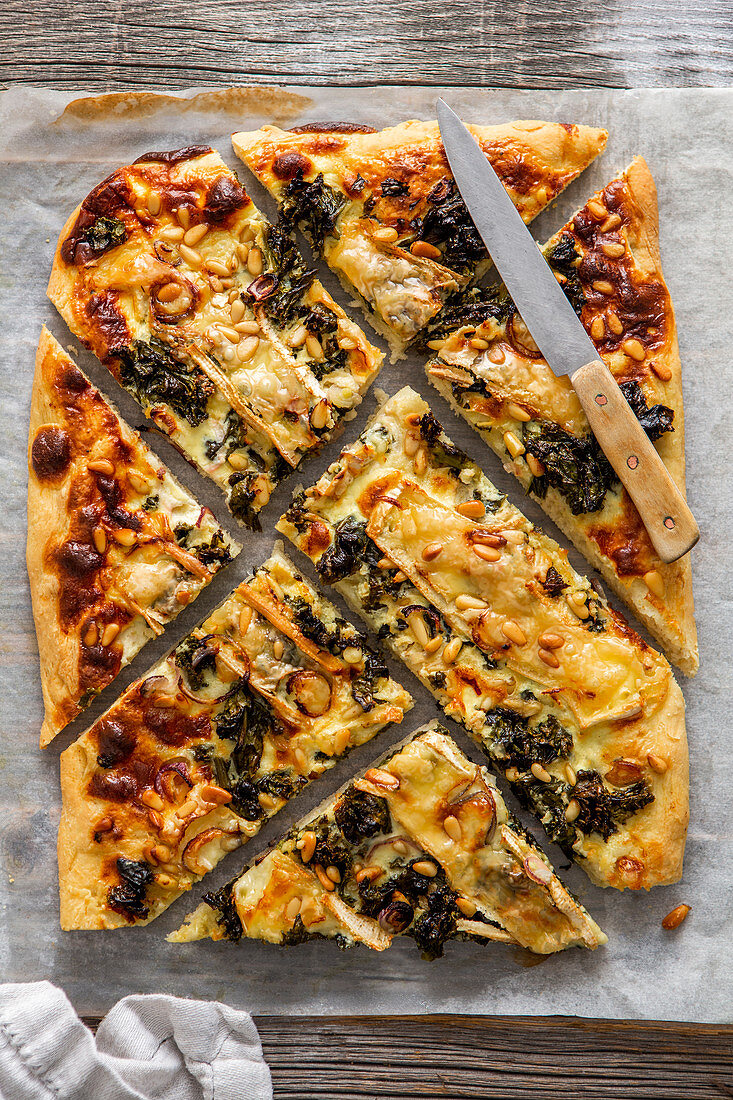 Pizza with cabbage, camembert and pine nuts