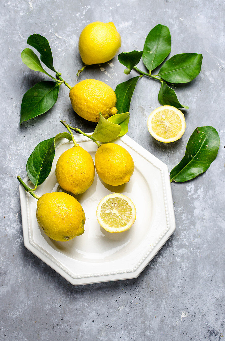 Zitronen, halbiert und ganz mit Blättern