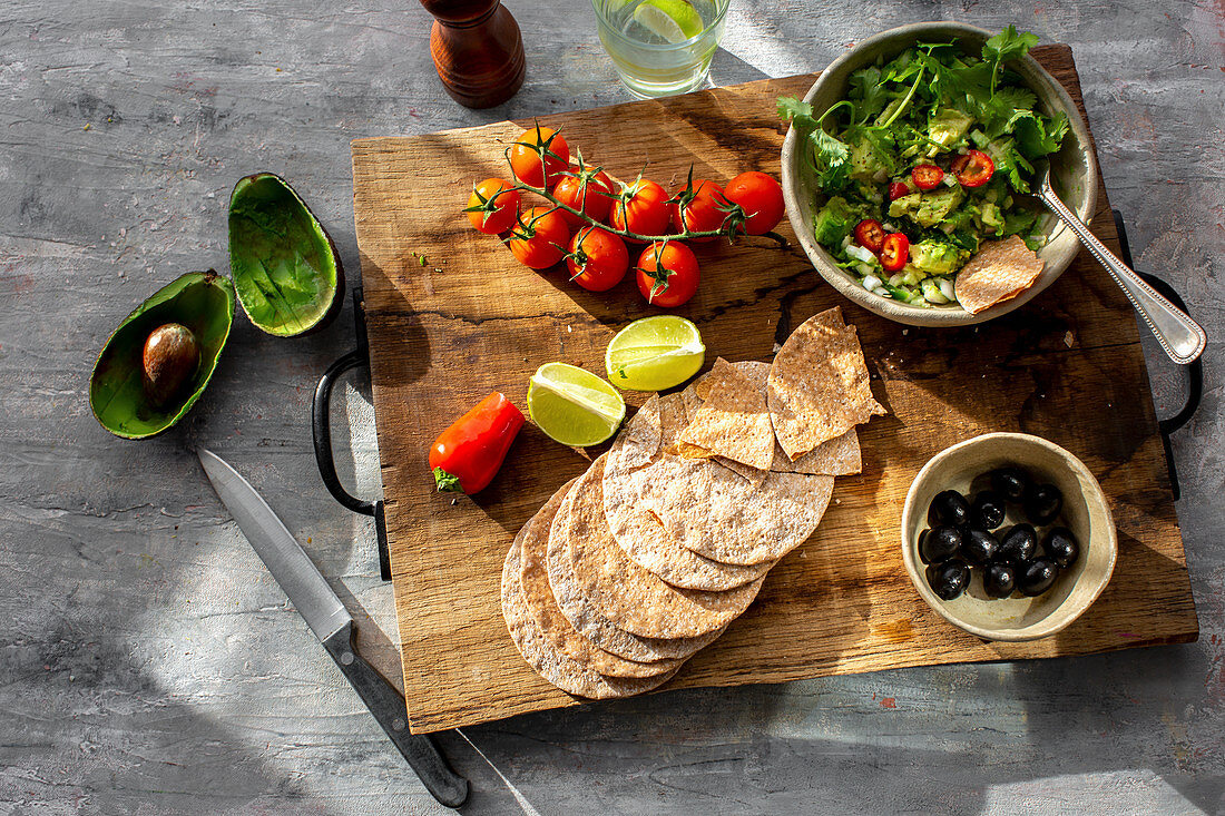 Guacamole mit Chili und Koriander serviert mit Crackern und Oliven