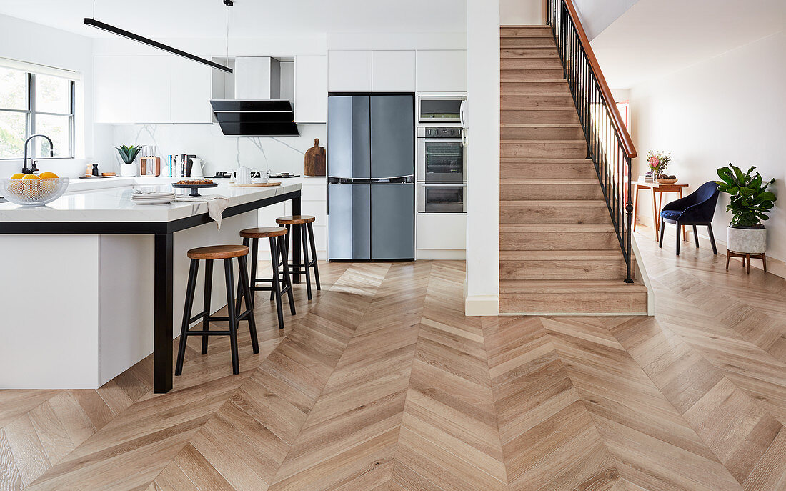 Open-plan kitchen, herringbone parquet floor and stairs in open-plan interior