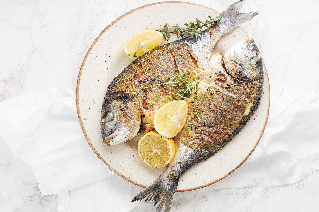 Fried sea bream with herbs and lemons