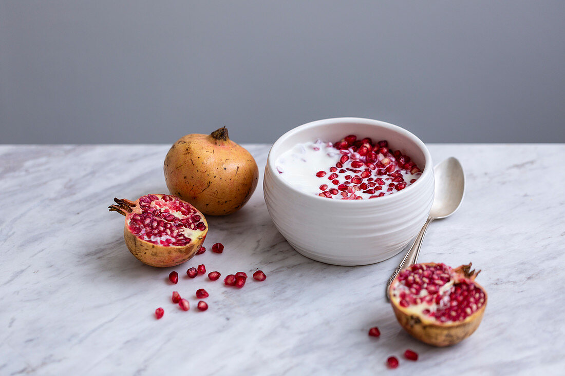Yogurt with pomegranate seeds in a ceramic bowl