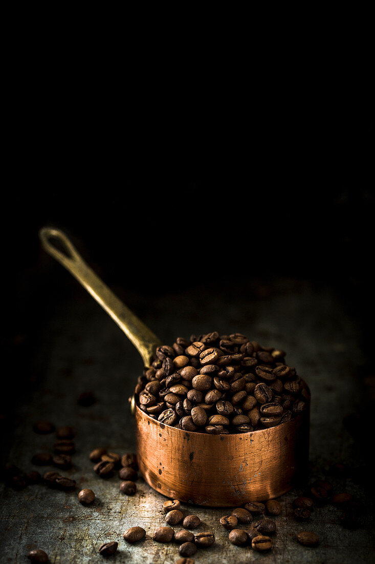 Fresh coffee beans in a copper saucepan