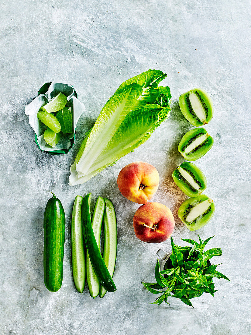 Zutaten für Detox-Diätgetränke: Pfirsich, Kiwi, Salatblatt und Gurke