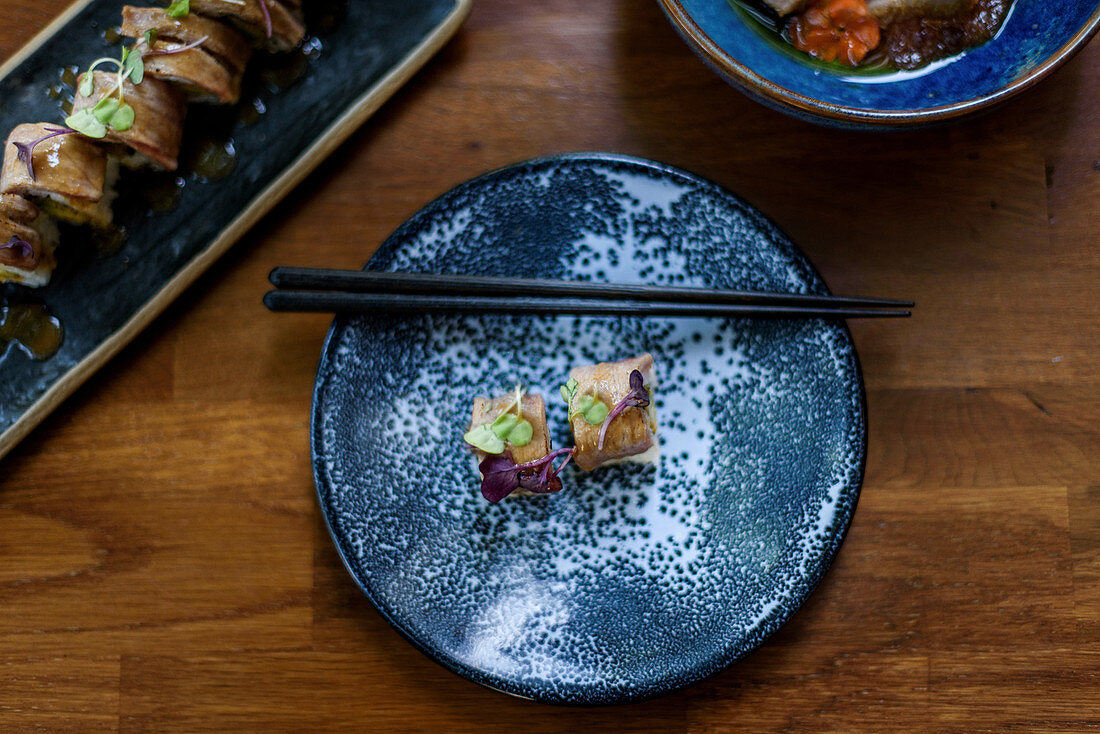 Sushi-Röllchen mit Reis und Lachs, garniert mit frischen Kräutern