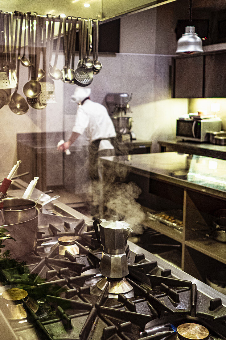 Dampfende Espressokanne auf Gasherd in einer Großküche
