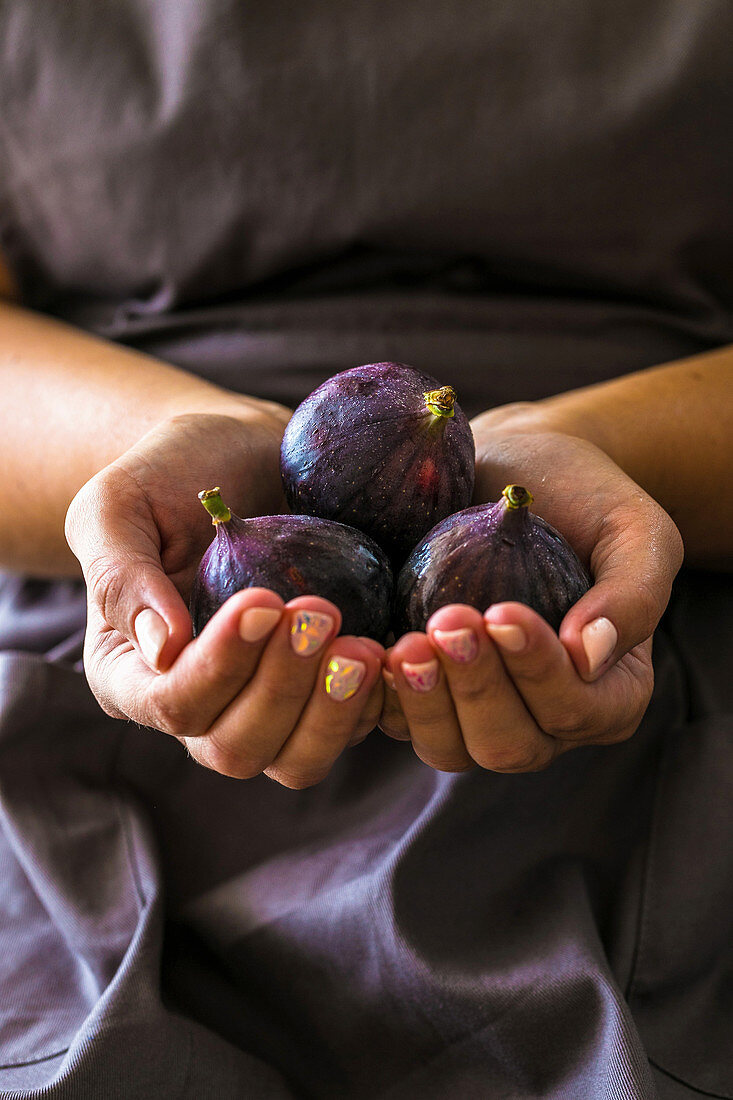 A woman holding fresh figs