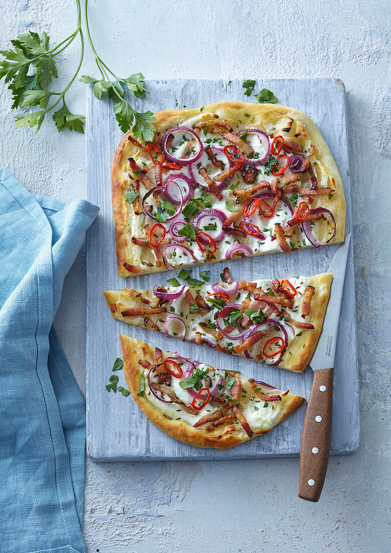 Pizza with red onions, chilli, bacon and cream