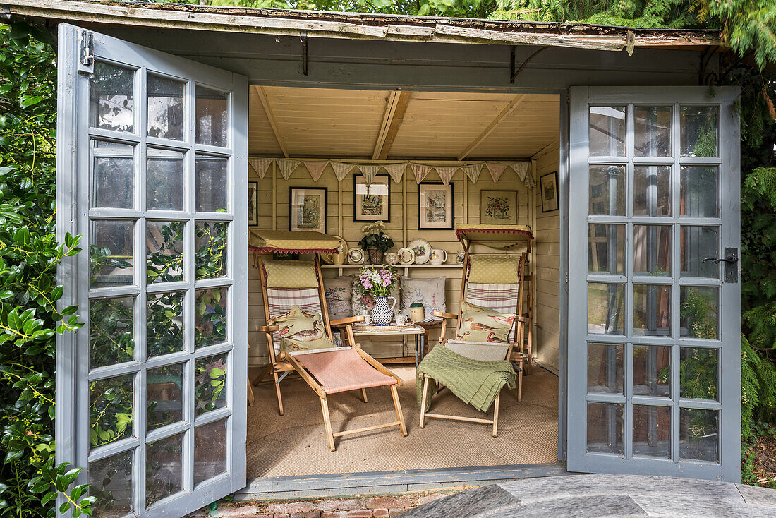 Vintage chairs upholstered in fabric remnants with a collection of 1950s embroidered pictures